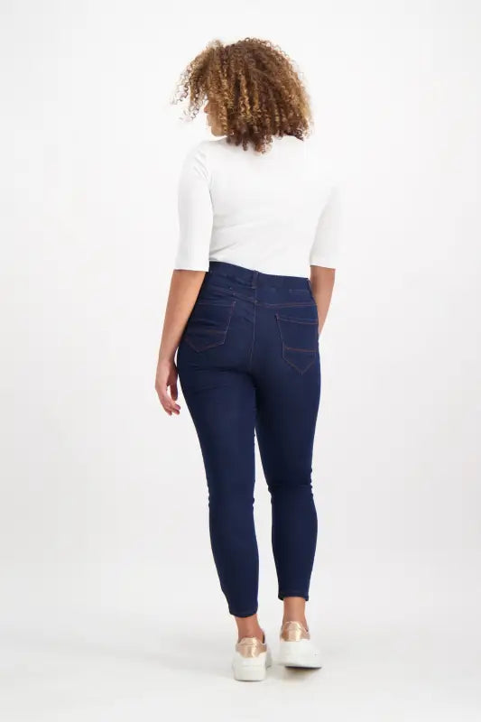 Women’s dark blue skinny jeans with a white short-sleeved top.