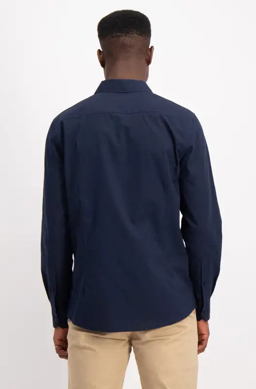 Men’s navy blue long-sleeve collared shirt with tan pants