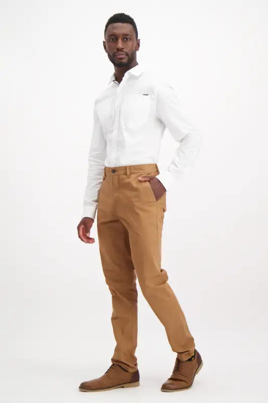 Men’s white long-sleeved shirt and brown pants with brown shoes.