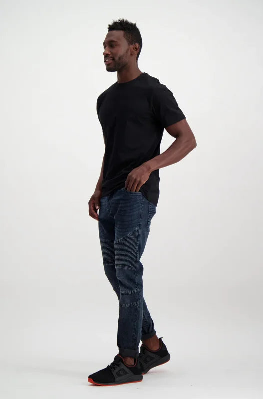 Men’s black short-sleeve t-shirt with dark blue skinny jeans and black sneakers.