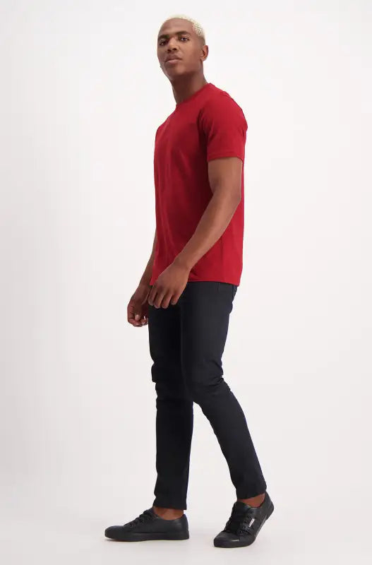 Men’s red short-sleeved t-shirt and dark pants.