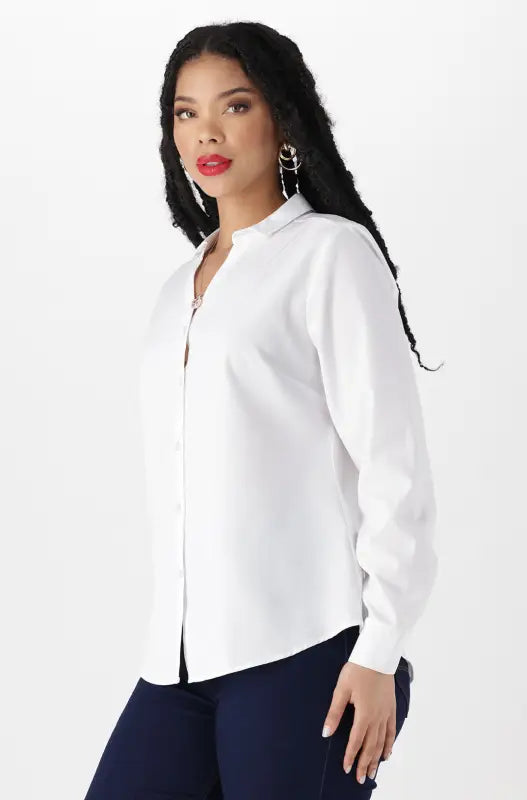 A woman wearing a white button-down shirt and dark blue pants.