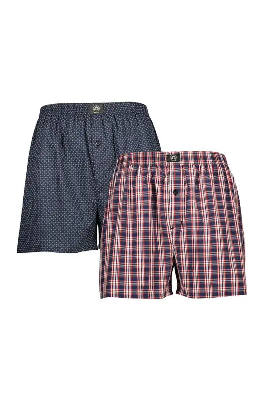 A two-pack of men’s woven boxer shorts, one in a dark blue with a small white polka dot pattern, and the other in a red, white, and blue plaid pattern, both featuring an elastic waistband and a button fly.