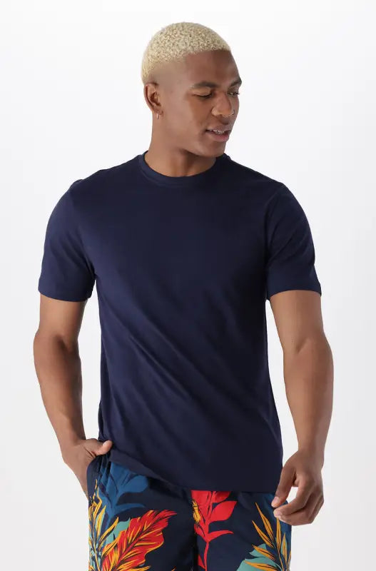 Men’s short-sleeve navy blue t-shirt with a crew neck, paired with navy blue shorts featuring a vibrant tropical leaf pattern.