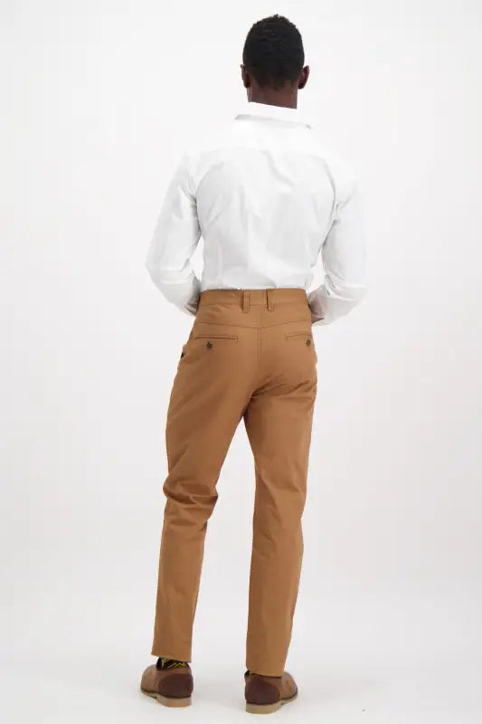 Men’s white long-sleeve dress shirt and brown flat-front pants.