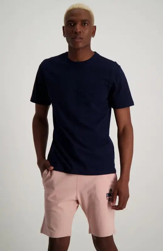 Men’s navy t-shirt and light pink shorts.