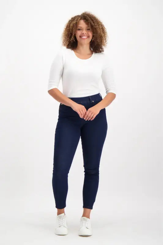Women’s white three-quarter sleeve top and dark blue skinny jeans.