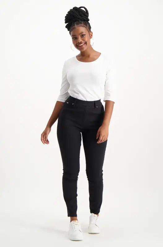 Women’s white long-sleeve t-shirt with black skinny pants.
