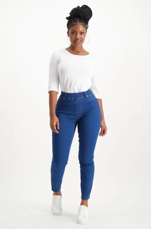 Women’s white three-quarter sleeve top and blue skinny jeans.