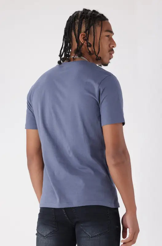 A man’s plain blue t-shirt and dark jeans.
