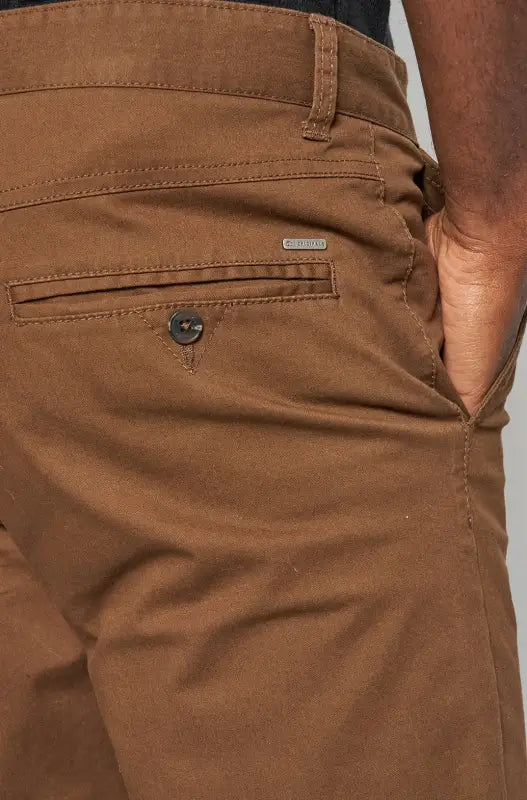 Men’s brown cotton chino pants with a buttoned back pocket.