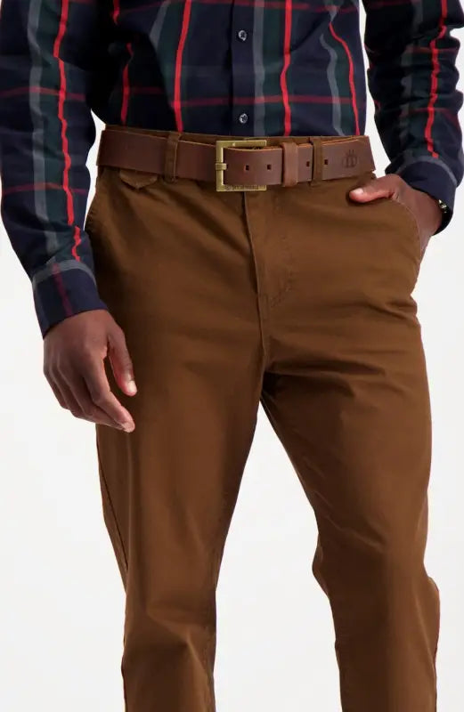 A man wearing a plaid shirt, brown belt, and brown pants.