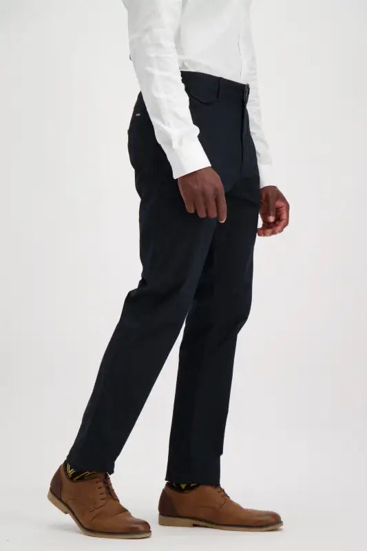 Men’s black trousers with a white button-up shirt and brown dress shoes.