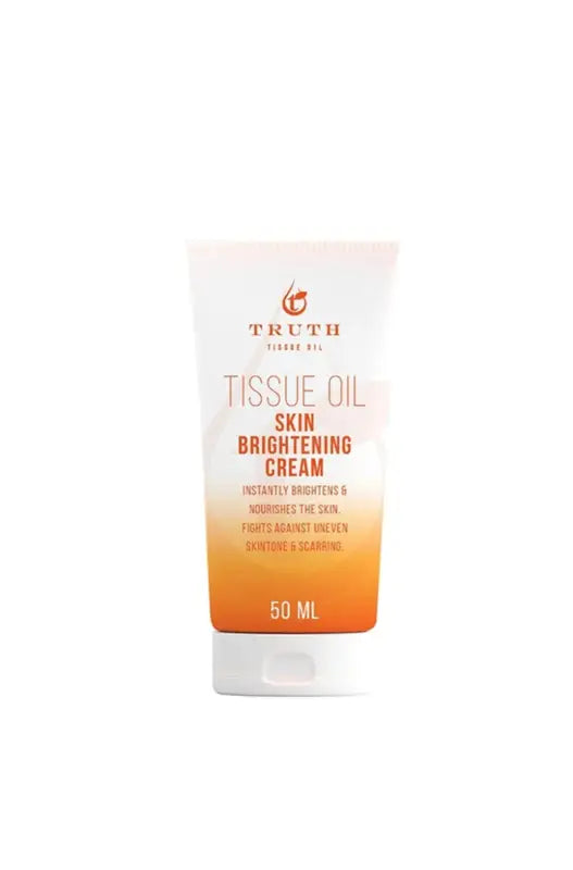 White and orange tube of skin brightening cream.