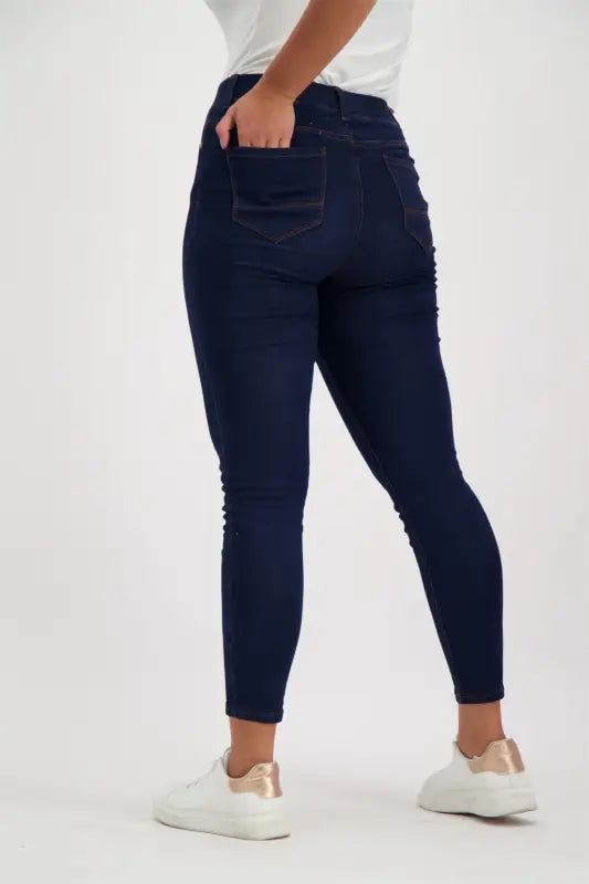 Dark wash skinny jeans with back pockets and side embellishments.