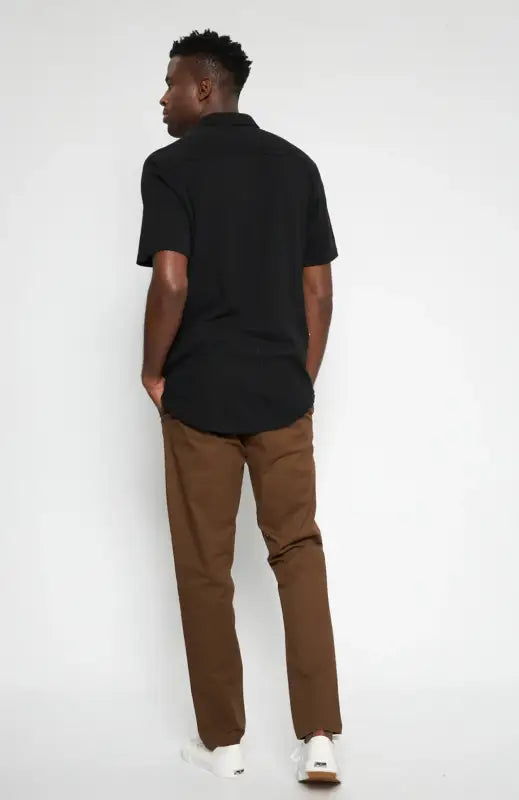 Men’s black short-sleeved collared shirt and brown pants.