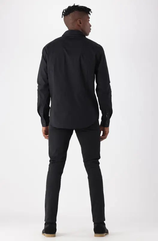 Men’s black long-sleeved button-up shirt with matching black trousers.