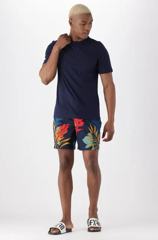 Men’s navy blue t-shirt and floral swim shorts.